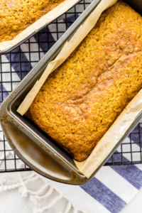 Moist loaf of richly spiced pumpkin bread just coming out of the oven, perfectly golden brown